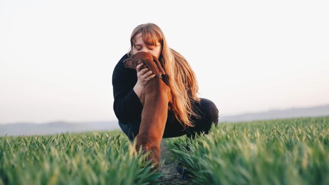 Woman cuddling dog